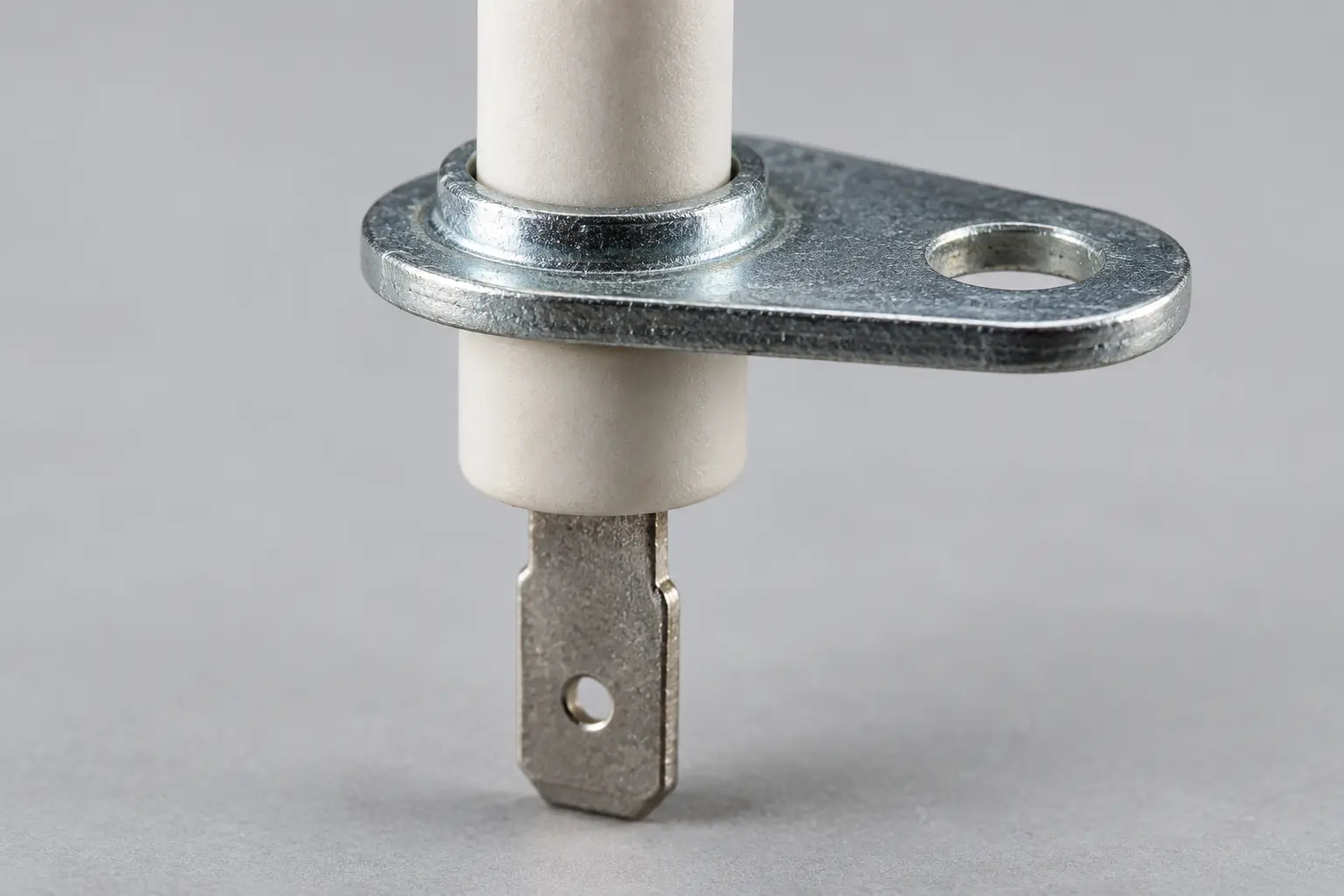 Close-up of the galvanized mounting flange and 2.8 mm flat tab terminal at the base of a boiler ignition electrode