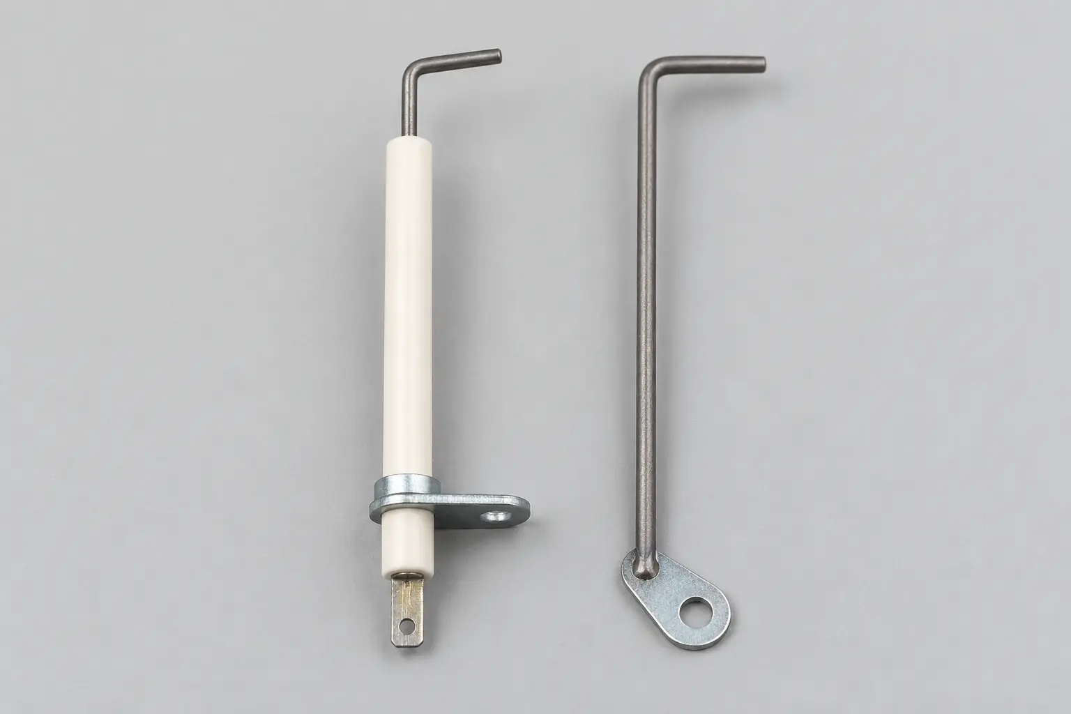 Boiler ignition electrode with alumina ceramic and galvanized flange beside a bent ionisation rod on a welded mounting plate